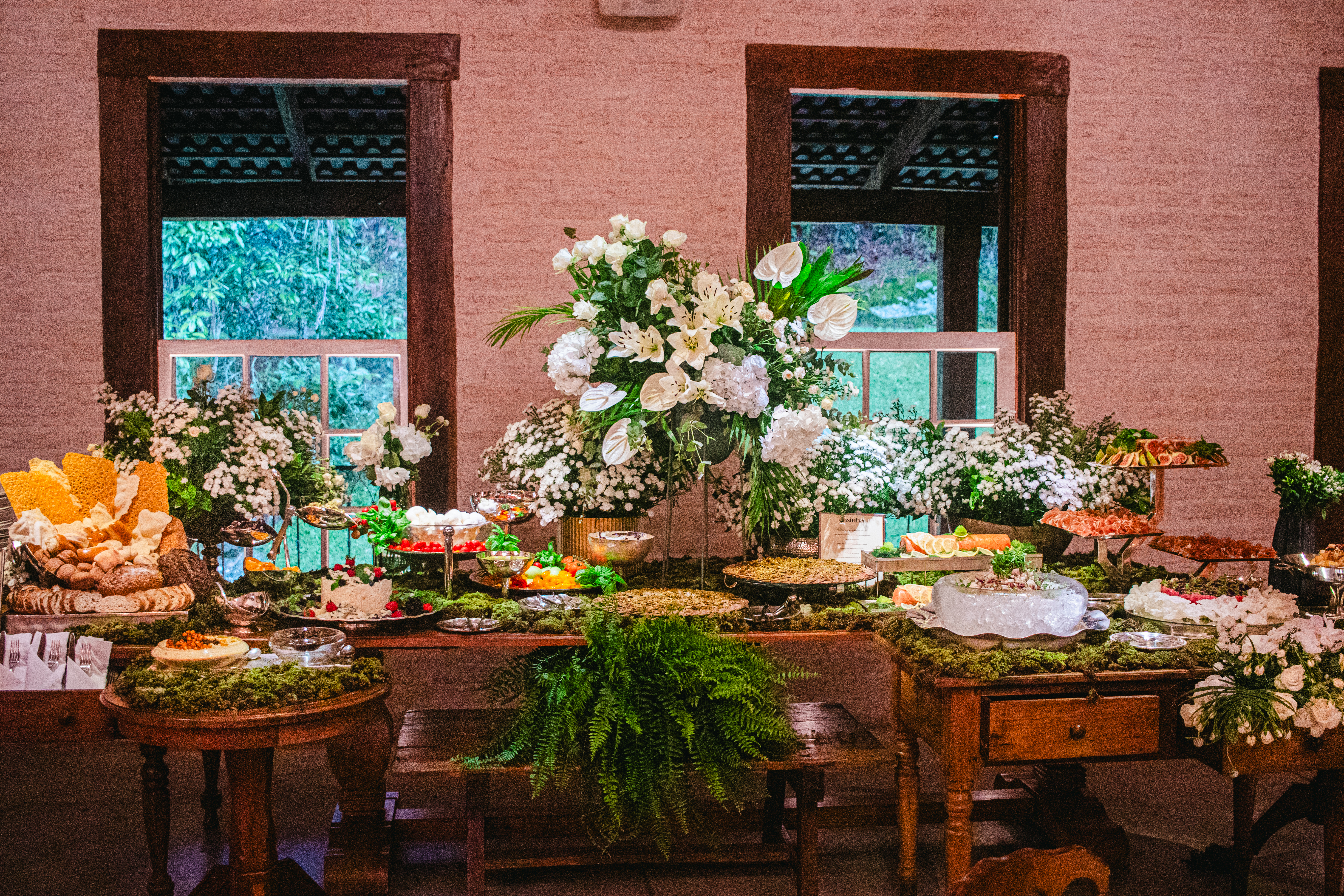 Buffet decorado com flores brancas e mesa de evento